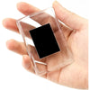 A clear square photo frame magnet with a black insert is held in a person's hand.