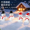 A collection of white resin snowman figurines with black top hats and red bows displayed on a snowy surface.