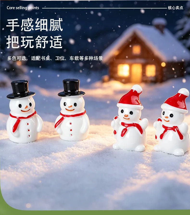A collection of white resin snowman figurines with black top hats and red bows displayed on a snowy surface.