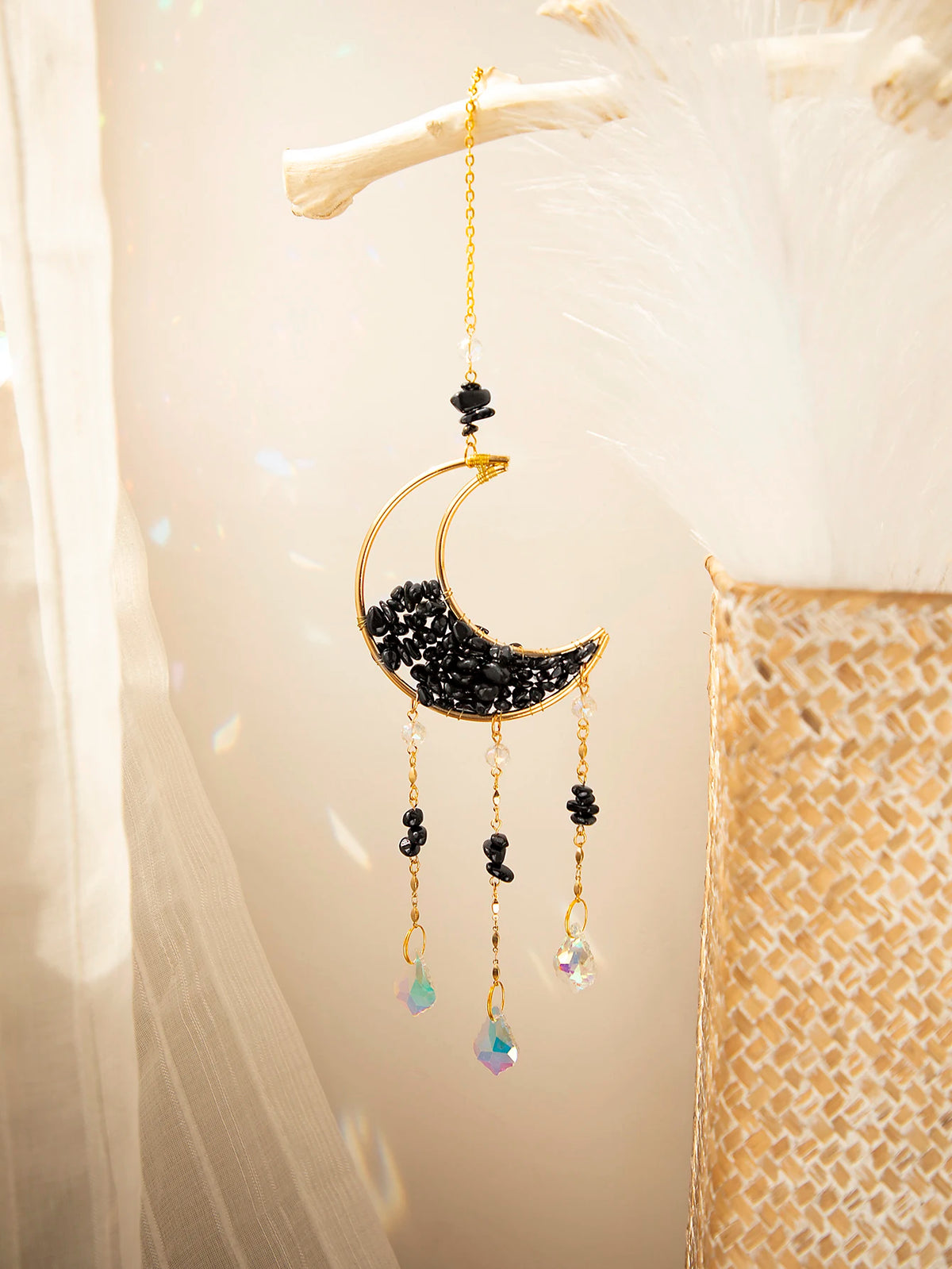 A handcrafted gold moon crystal suncatcher with a black crescent pendant and dangling prism charms.