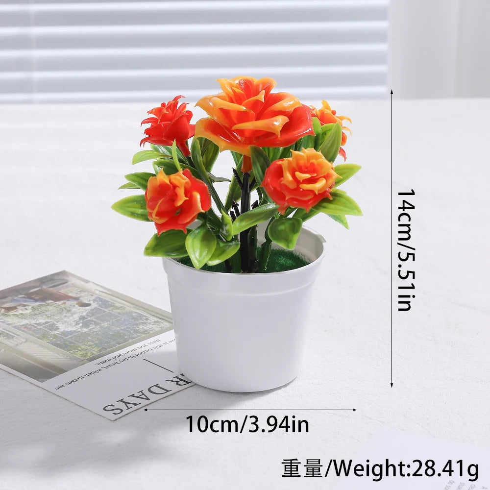 An artificial orange and red rose bonsai tree decoration in a white pot.