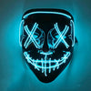 A black mask with glowing blue LED lines forming an 'X' pattern and a jagged smile, mounted on a wall.