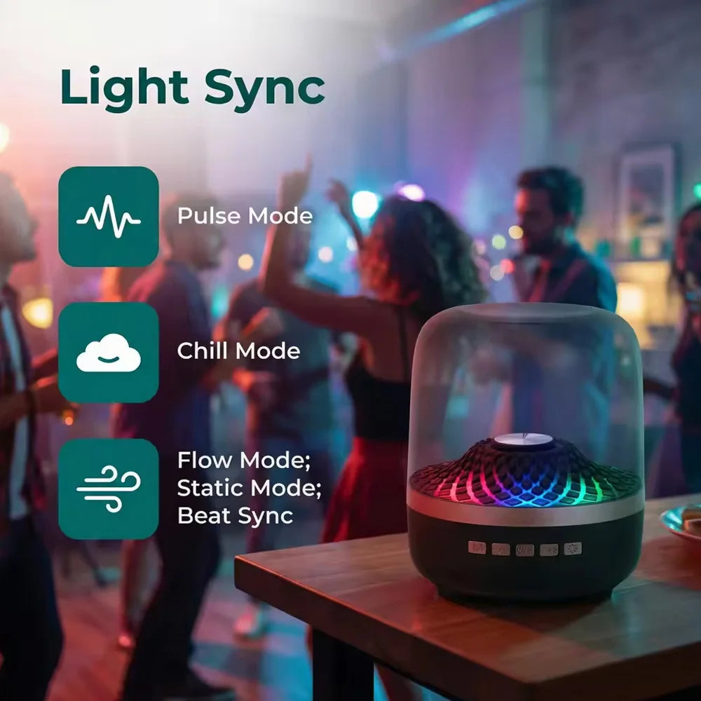 A transparent RGB Bluetooth speaker is displayed on a wooden table in a dimly lit room with people in the background.