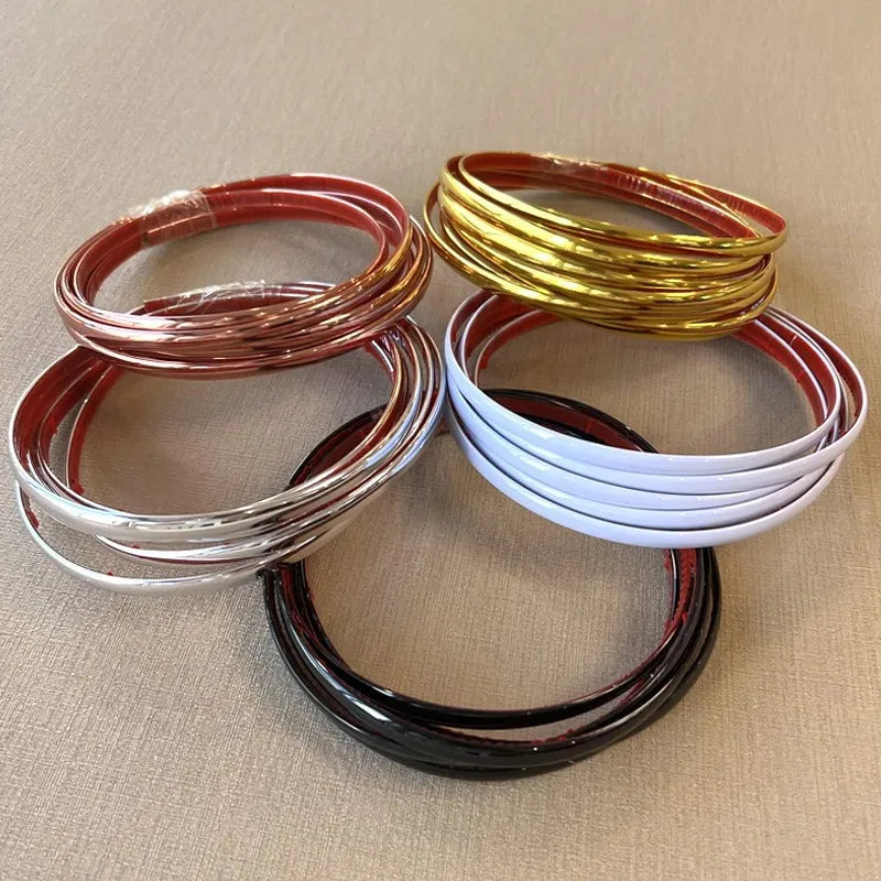 A collection of self-adhesive PVC wall trim tape in various colors including copper, gold, red, white, and black coils.