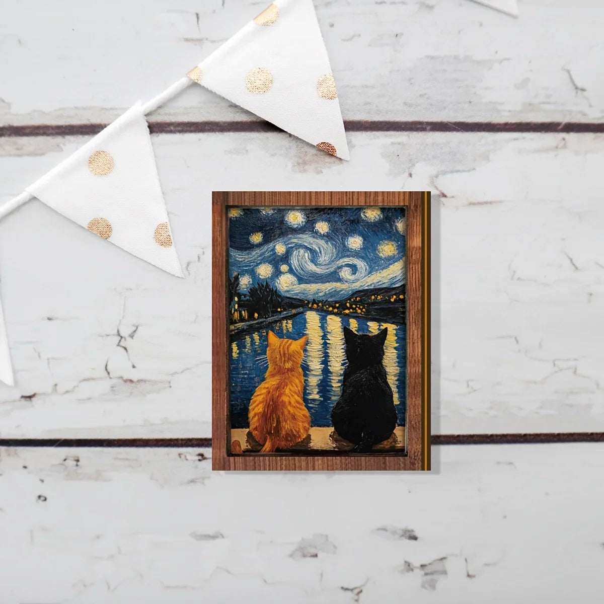 A wooden art print depicting two cats silhouetted against a starry night sky and water.