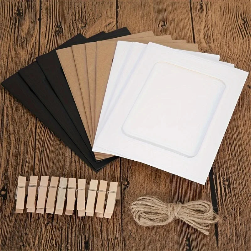 A stack of vintage kraft paper photo frames and a bundle of small wooden photo strips on a wooden surface.