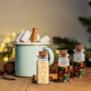 Decorative glass vials filled with various dried herbs and spices, set against a blurred background.