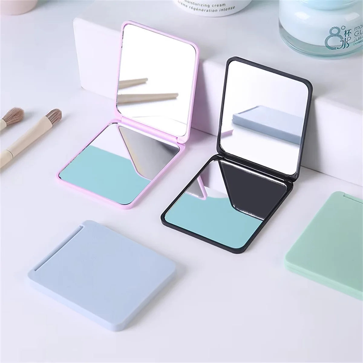 Set faltbarer Make-up-Spiegel in Hellblau und Pink, inklusive Ständer und Kompaktspiegel.