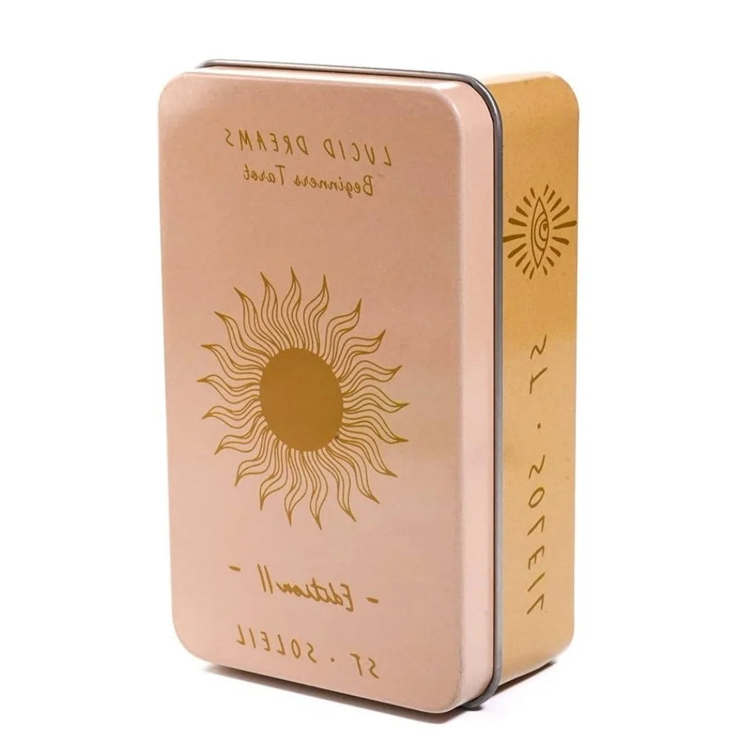 A vintage art tarot oracle card deck in a rose gold metal tin with a sun design.
