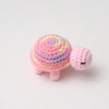 Handmade crocheted turtle plush toy with pink and purple stripes.
