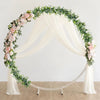 A white draped archway decorated with a lush garland of pink roses and green eucalyptus vines.