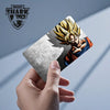A hand holds a card featuring a Dragon Ball Super Saiyan character design.