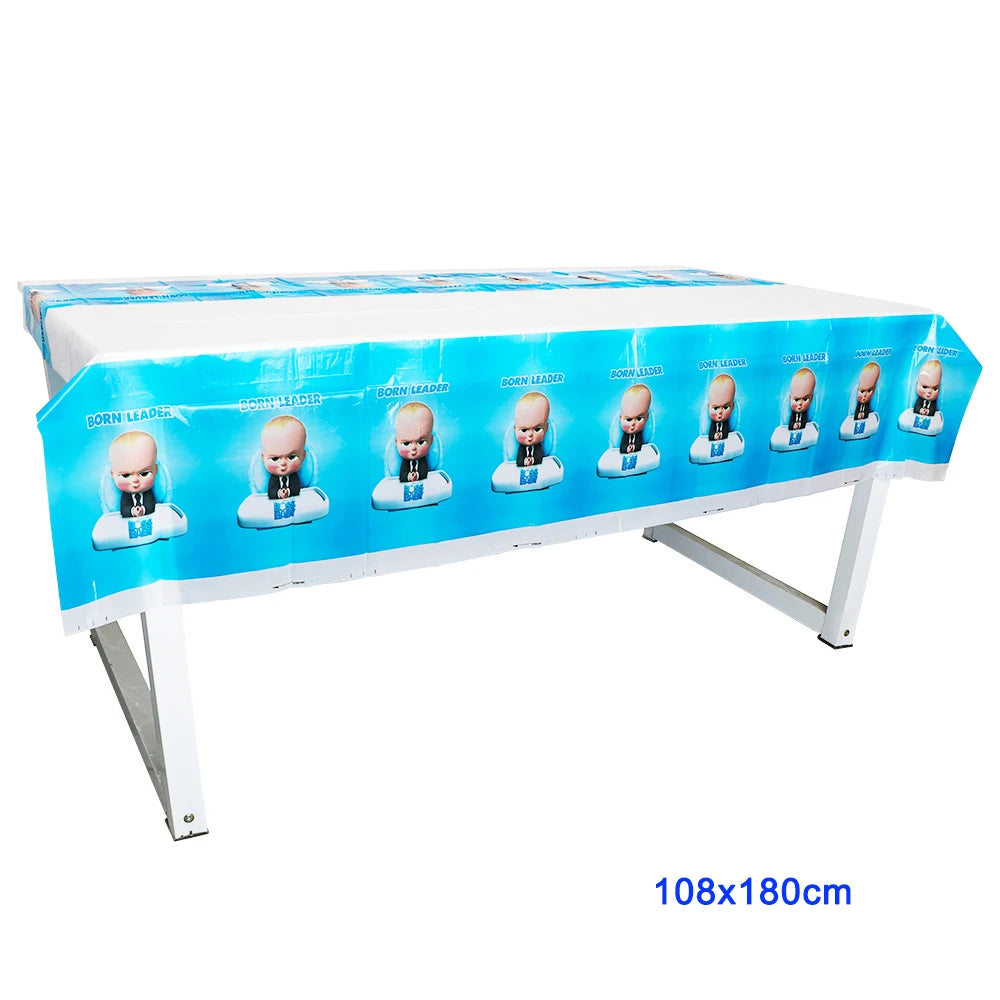 A long table covered with blue and white baby boss themed decorations and disposable tableware set.