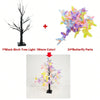 A black birch tree light features 24 butterfly parts with a warm glow, displayed on a stand.