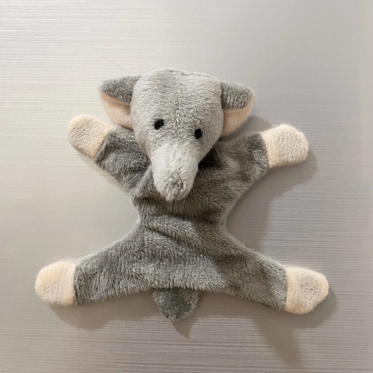A soft gray elephant plush toy with light beige accents, designed as a fridge magnet.