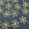 Gold glitter snowflakes scattered across dark blue fabric