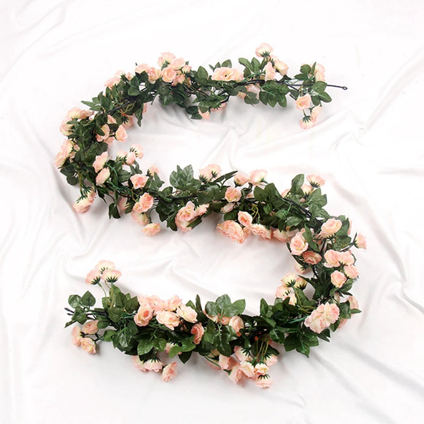 A green silk rose vine garland shaped like the letter G, featuring pink and peach roses.
