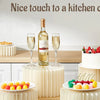 Supports en acrylique pour aliments présentant des fruits et desserts sur un comptoir de cuisine.