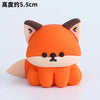 An orange fox-shaped decoration with black facial features and pink inner ears.