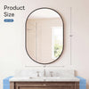 Oval wall mirror with a black metal frame hanging above a marble vanity top.