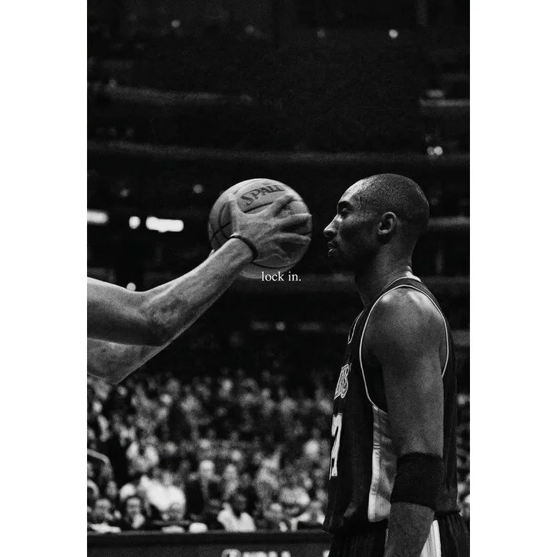 Black and white photo of a basketball player in a jersey preparing to shoot, focusing on his arm and face.
