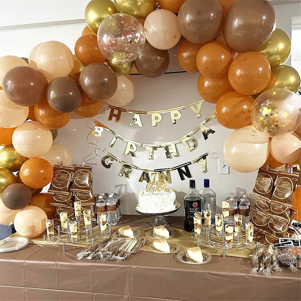 A display of gold, bronze, and orange latex balloons decorated for a birthday or wedding party.