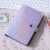 A purple glitter leather cash envelope binder with a silver clasp resting on a pink fabric next to a stack of money.