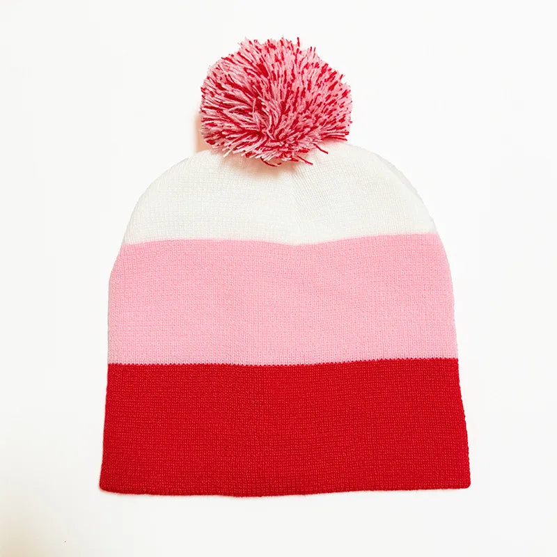 A knitted beanie with horizontal stripes of white, pink, and red, topped with a pink pom-pom.