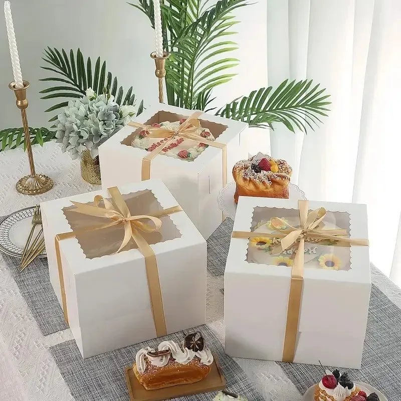 White bakery boxes with window containing disposable cake and pastry items