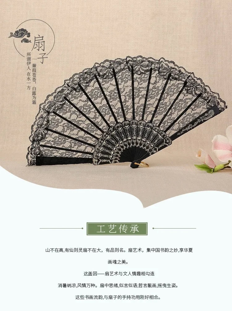 A vintage lace folding fan featuring a black and white design, displayed against a beige background.