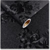 A sheet of vintage black floral self-adhesive contact paper is shown diagonally, revealing a rolled edge.