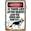 A vintage metal sign with a black and white graphic warning that asks Is there life after death? Jump the fence and find out!