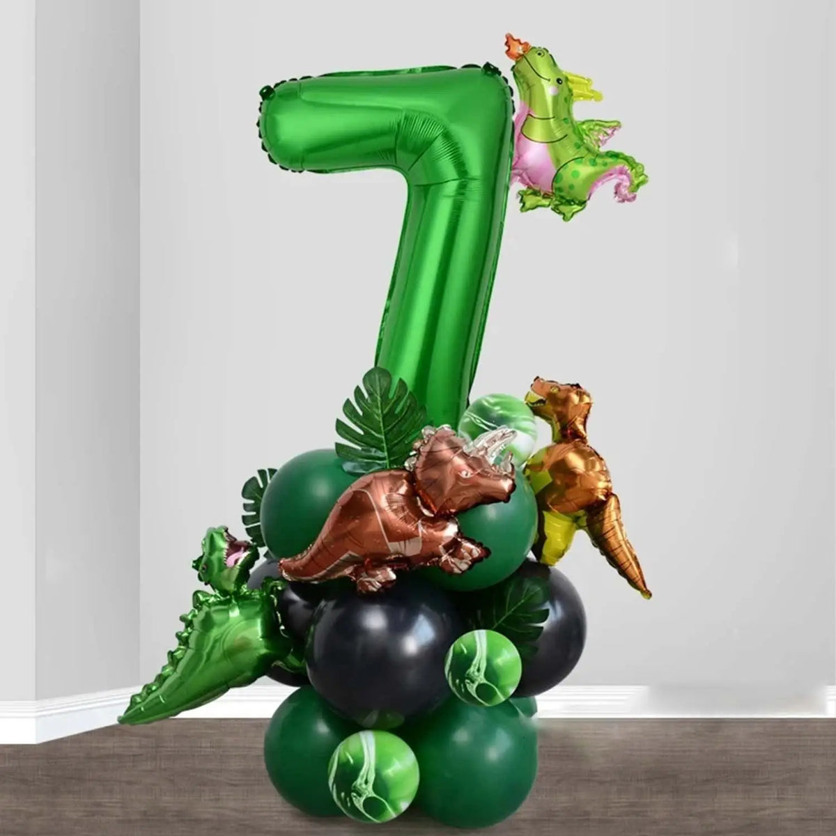 A set of green and gold dinosaur-themed balloons shaped like the number 7 and various dinosaurs for a party decoration.