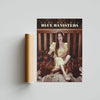 Album cover art for Blue Banisters featuring a woman in yellow sitting among dark brown dogs.
