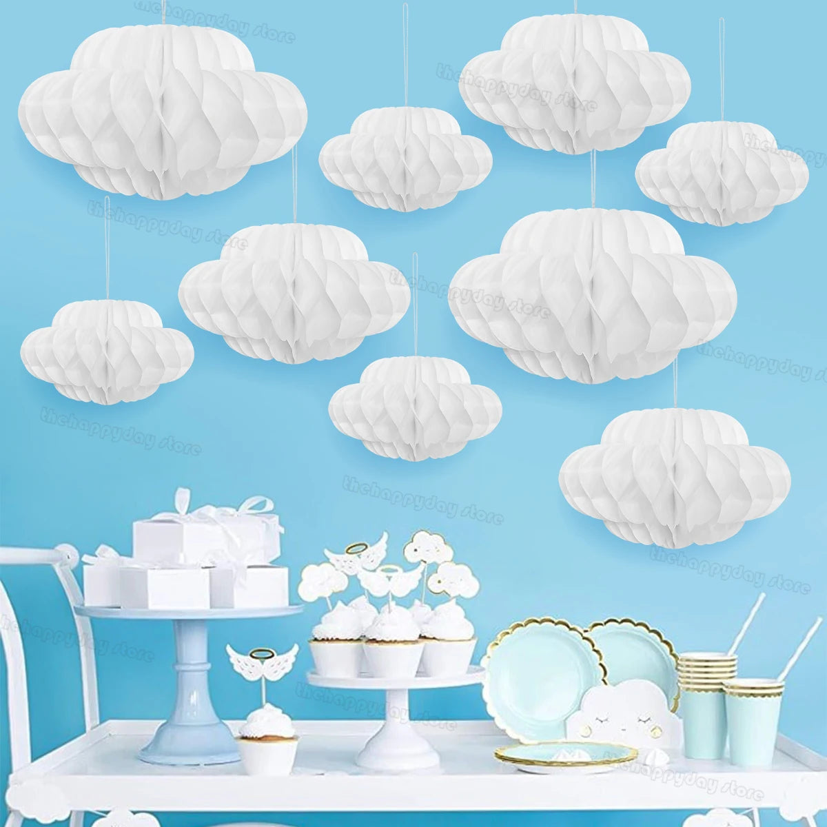 A white 3D cloud honeycomb ball decoration set displayed on a white table with small pastries.
