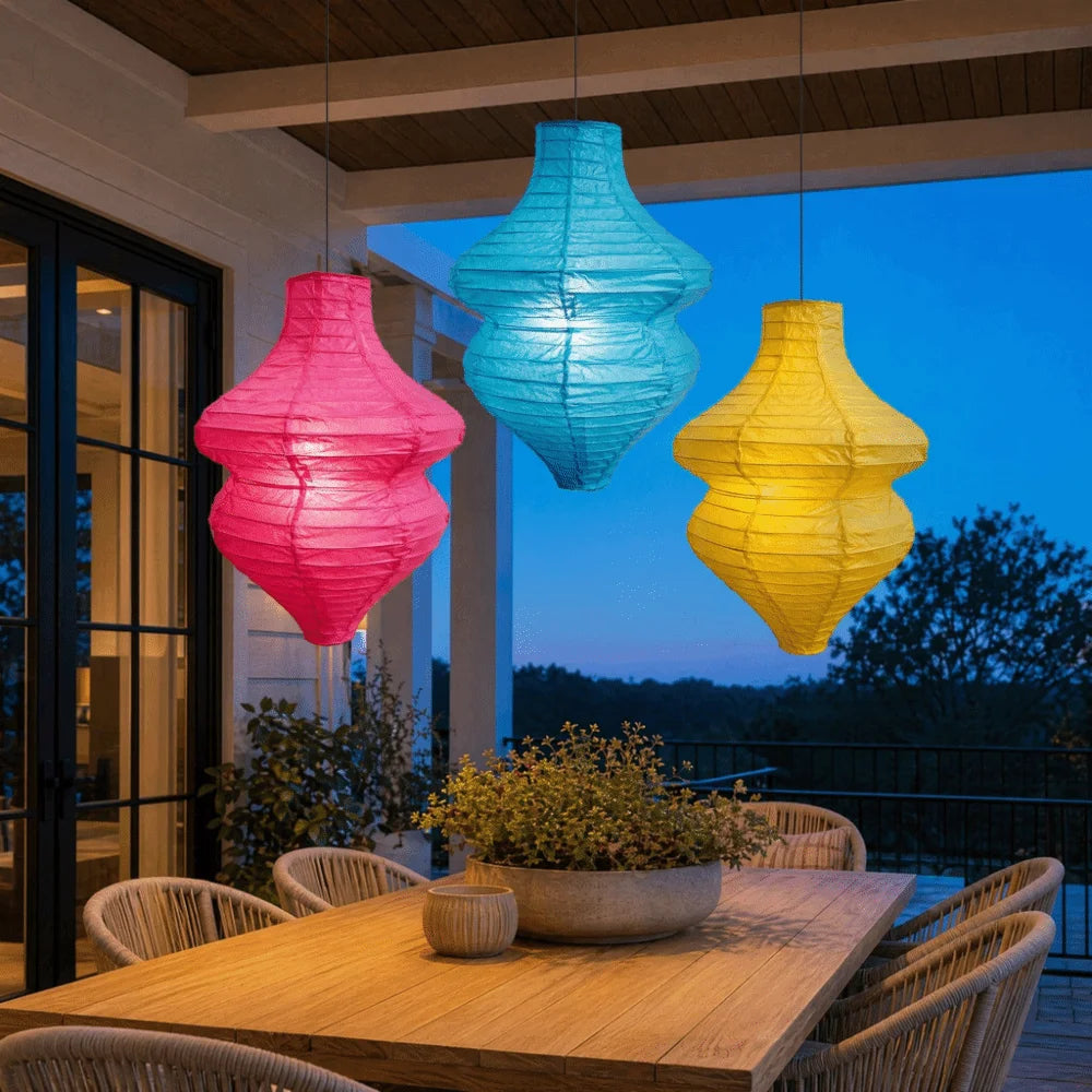 A set of handmade vintage flower bottle lanterns hanging in front of a modern house at twilight.
