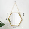 A gold-framed hexagon wall mirror hanging by a chain, shown against a white background.