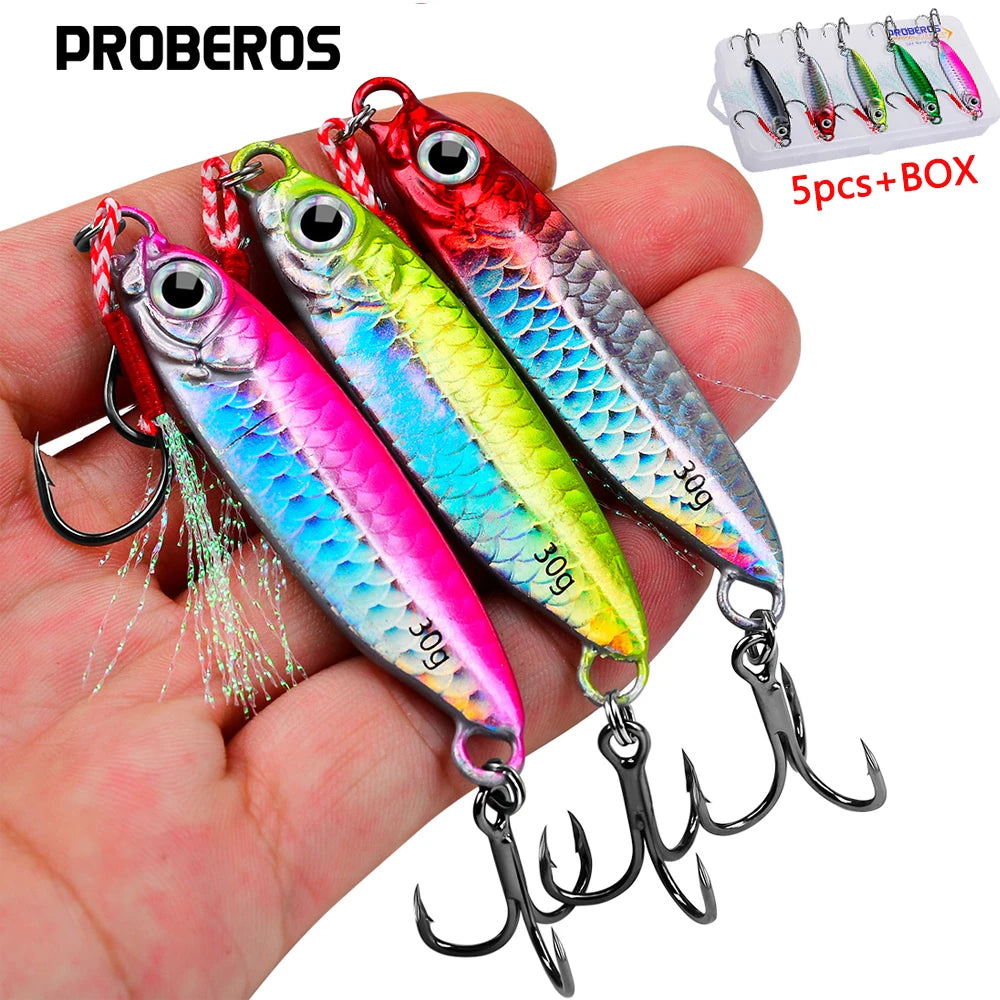 A hand holds a set of metal jig fishing lures with hooks and a storage box.