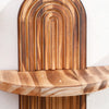 Two wooden wall shelves with arched designs mounted on a white wall.