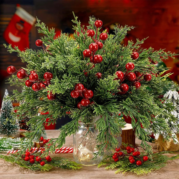 A festive arrangement of artificial Christmas berry stems and pine branches in a glass jar.
