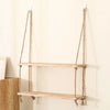 A rustic floating wooden storage shelf with natural twine hangers mounted on a light-colored wall.