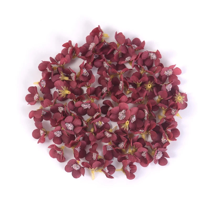 A cluster of deep reddish-purple silk artificial flower heads used for weddings, crafts, and home decor.