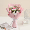 A pink handmade crochet rose flower bouquet wrapped in sheer paper and tied with a ribbon