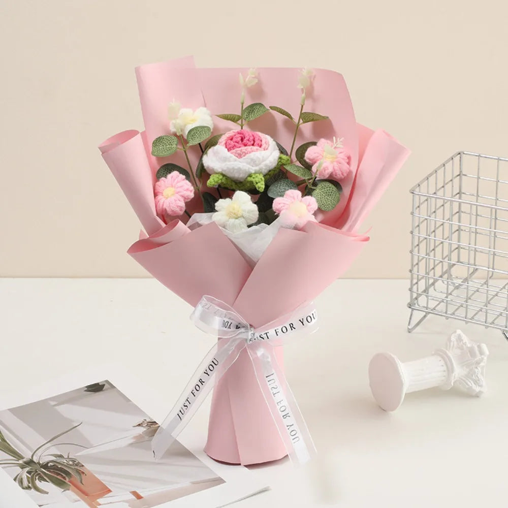A pink handmade crochet rose flower bouquet wrapped in sheer paper and tied with a ribbon