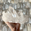 A hand holds a cluster of clear quartz crystals for home decor.