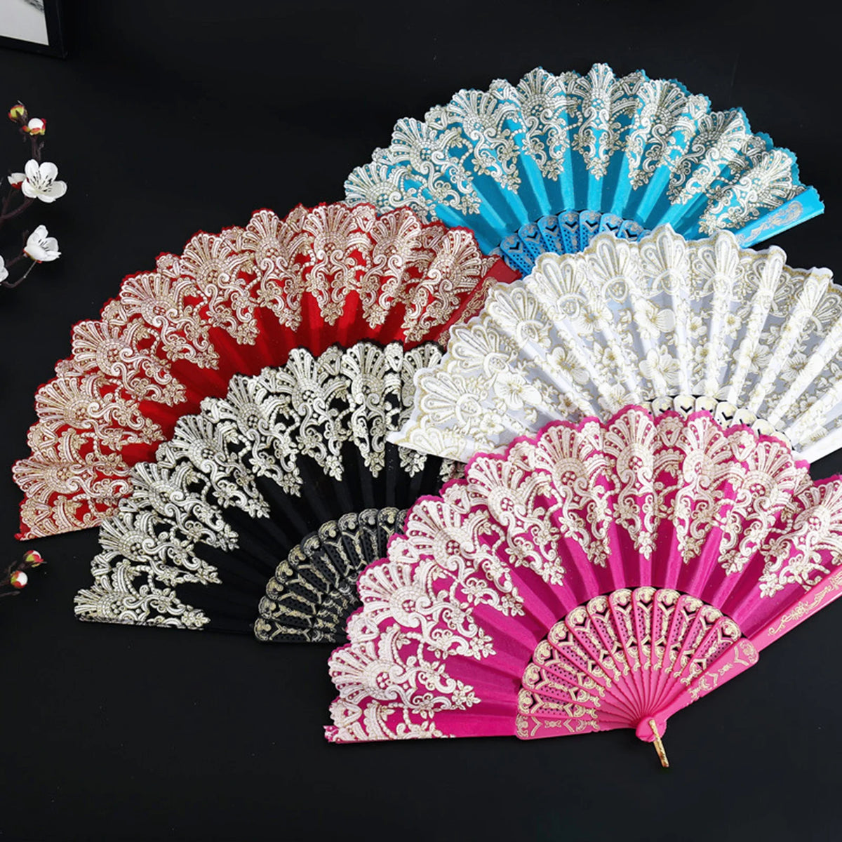 A collection of five elegant folding fans in various colors including red pink white and blue with intricate traditional Chin