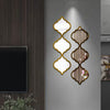 Decorative wall stickers featuring gold-edged, diamond-shaped acrylic mirrors on a gray wall.