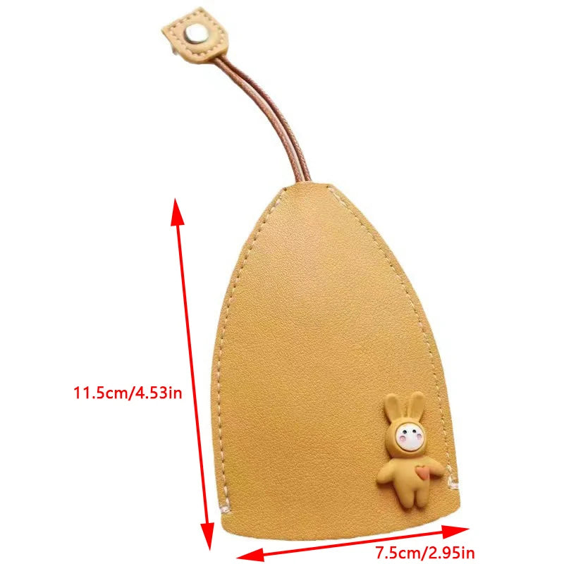 A tan cartoon PU leather key holder with a pull-out design and attached leather cord.