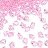 Pink decorative crushed diamond acrylic pebbles scattered on a white background