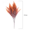 A spray of reddish-brown artificial daisy-like foliage arranged in a vertical bouquet.